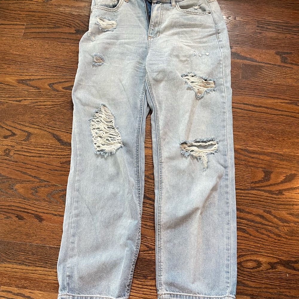 Faded, ripped, light wash blue jeans, loose, baggy